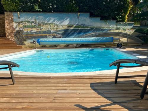 une piscine d'eau bleue devant un tableau dans l'établissement appartement spacieux avec piscine à 15 minutes d'Hossegor, à Saint-Vincent-de-Tyrosse