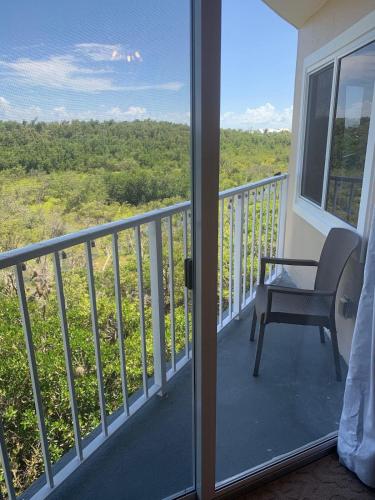 a room with a balcony with a chair and a view at Ocean Pointe Resorts - Serenity 2308 in Tavernier