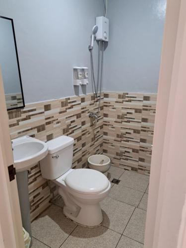 a bathroom with a toilet and a sink at Sleep Zone Hostel in Moalboal
