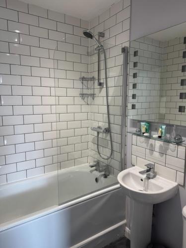 a white bathroom with a sink and a tub and a sink at Oaklands Hotel in Norwich