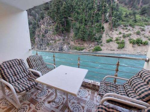 a table and chairs on a balcony with a view at Hotel Birmingham Palace Kalam by Khan Familia Travels in Kalām