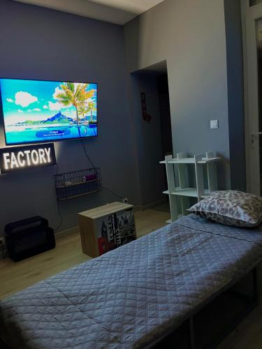 a bedroom with a bed and a flat screen tv at FactoryLoftCosy Gare à 5mins in Bellegarde-sur-Valserine