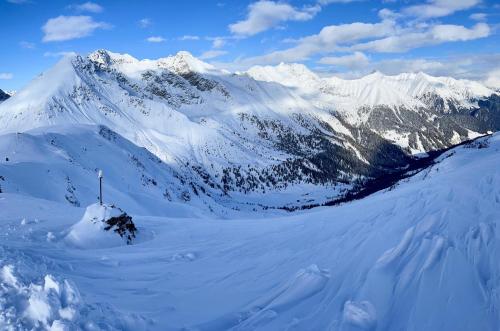 a snow covered mountain with a flag in the snow at Apartment in South Tyrol with a beautiful panoramic view in Verano