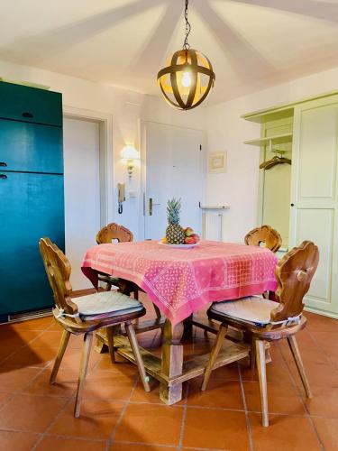 a dining room with a pink table and chairs at Apartment in South Tyrol with a beautiful panoramic view in Verano
