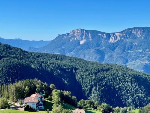 a house on a hill with mountains in the background at Apartment in South Tyrol with a beautiful panoramic view in Verano