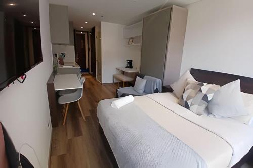 a hotel room with a bed and a desk and a table at hermoso apartamento Taj 97- 629 in Bogotá