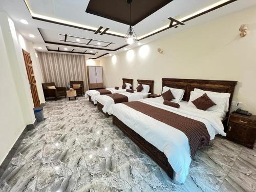a hotel room with three beds in a room at Hotel Birmingham Palace Kalam by Khan Familia Travels in Kalām