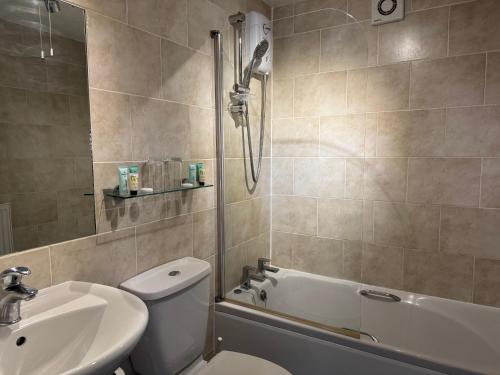 a bathroom with a toilet and a sink and a shower at Oaklands Hotel in Norwich