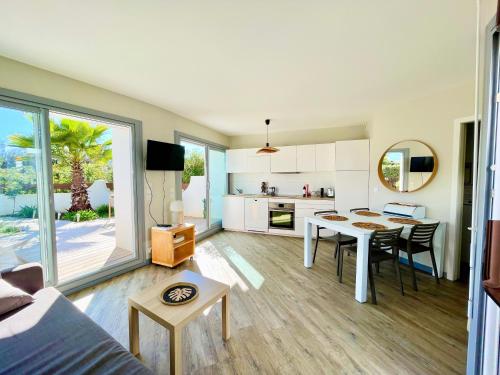 un salon avec une table et une cuisine dans l'établissement PGH N3 - Maison de Plage avec Parking Privé, à La Grande Motte