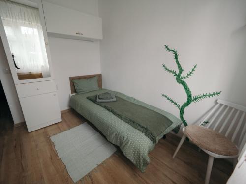 a bedroom with a green bed and a chair at Mimosa Studio in Cluj-Napoca