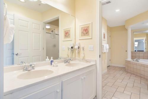 a bathroom with two sinks and a large mirror at Lake Access-Spacious Condo-Free Attraction Tickets-Deck Area in Kimberling City