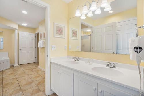 a bathroom with two sinks and a large mirror at Lake Access Condo-Free Daily Tickets-Peaceful Views-Expansive in Kimberling City