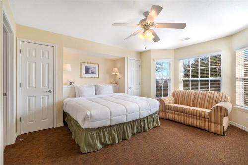 a bedroom with a bed and a chair and a ceiling fan at Ozark Vista 129 in Kimberling City