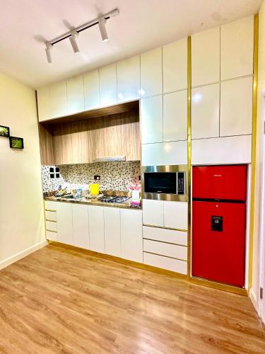 a kitchen with white cabinets and a red door at Salpa Homes in Aso
