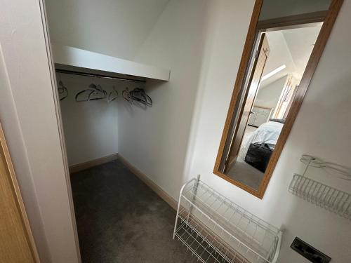 a hallway with a mirror and a bed in a room at 32 Cherry-Lodge-Tranquil-Hot Tub-Fishing Lake-7m to beach in Garton