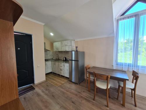 a kitchen with a table and chairs and a refrigerator at Guest House Rustaveli in K'obulet'i