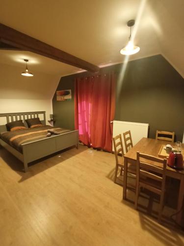une chambre avec un lit, une table et des chaises dans l'établissement Logis Dézamy chambre d'hôtes, à La Couture