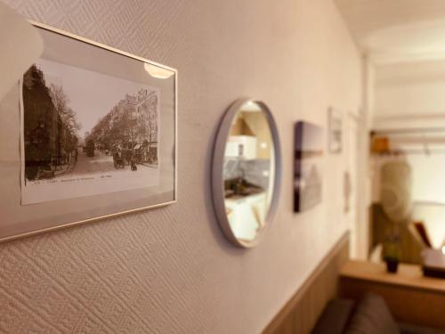 un miroir sur un mur avec une photo dans l'établissement Douillet Rue Saint-Gervais - 369, à Rouen