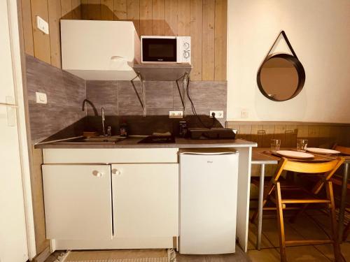 une cuisine avec un évier et un micro-ondes dans l'établissement Douillet Rue Saint-Gervais - 369, à Rouen