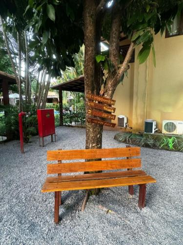 a wooden bench sitting next to a tree at Apartamento A-11 Pipa Beleza Resort in Pipa