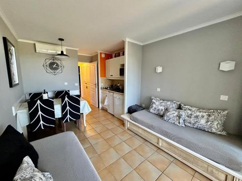 un soggiorno con divano e cucina di Les Restanques 1030 Arum rez de jardin a Grimaud