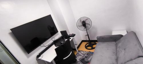 a living room with a couch and a flat screen tv at DPMC Stay and Play Vacation Unit in Cainta