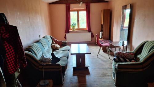 a living room with two couches and a table at Pensjonat Stara Szkoła in Piaseczno