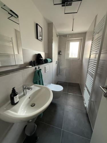 ein weißes Badezimmer mit Waschbecken und Toilette in der Unterkunft Apartment 2 Chic Chamber in Hannover