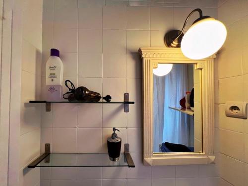 a bathroom with a mirror and a bottle of soap at Apartament Sant Feliu de Guíxols downtown in Sant Feliu de Guixols