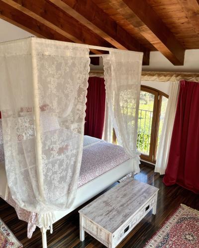 a bedroom with a bed with curtains and a table at Country Home B&B Il Melo in Vicenza