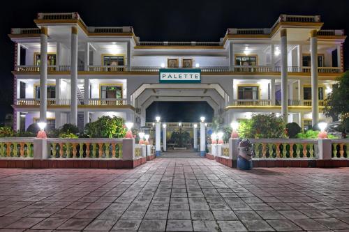 un grand bâtiment blanc avec un portail la nuit dans l'établissement Palette - Hotel ICON Bakkhali, à Bakkhali