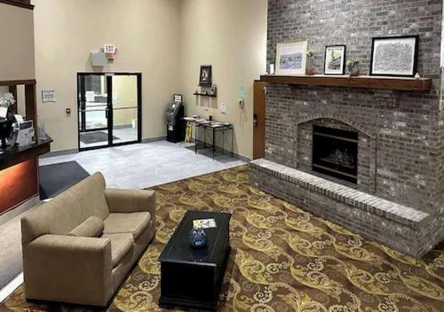 a living room with a couch and a fireplace at Quality Suites Near West Acres in Fargo
