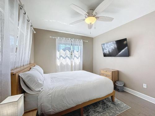 クリアウォーターにあるPool - Fire Pit - Fenced Yard - 5 mi to Beachのベッドと天井扇風機のある寝室