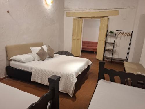 a bedroom with a bed with white sheets and pillows at Lotus Central Hotel in Santa Marta
