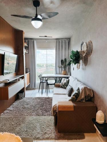a living room with a couch and a table at Apto em condomínio, vista lagoa in Três Lagoas