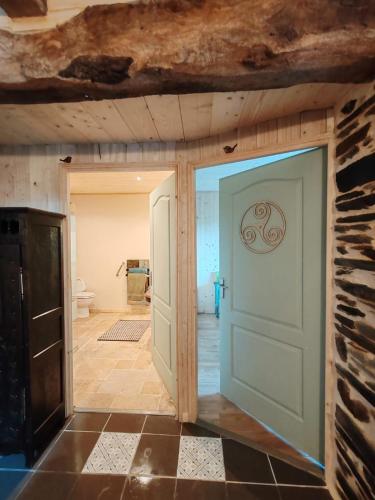une porte ouverte dans une chambre avec salle de bains. dans l'établissement ar wezenn gozh, à Laniscat