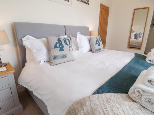 a bedroom with a large white bed with pillows at Sundowners in Southwold