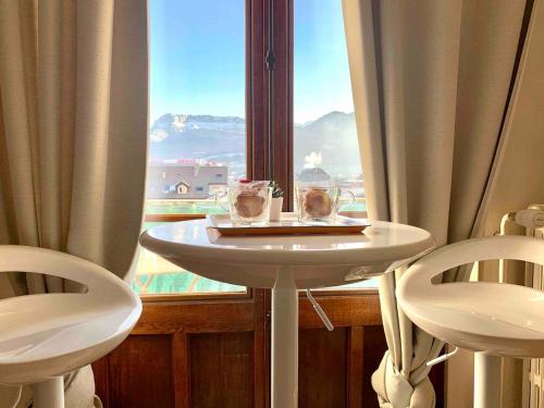 une table et deux chaises devant une fenêtre dans l'établissement Martine a Annecy parking vue magnifique, à Annecy