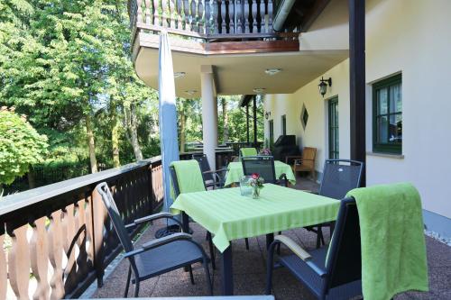 a table and chairs on a porch with a balcony at Landhotel Villa Moritz garni in Oberahr