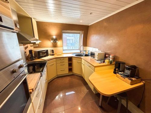 a small kitchen with a wooden table in it at Le Green Field Lodge - Parking Gratuit - Standing - Centre Ville - Commerces à Proximité in Lingolsheim