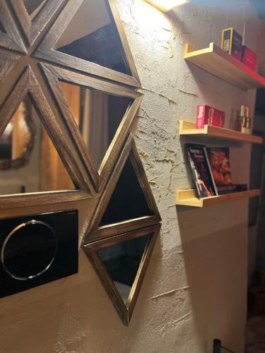 a mirror hanging on a wall with a shelf at Chalet 44 in Pinerolo