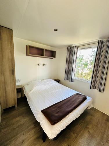 une chambre avec un grand lit et une fenêtre dans l'établissement Mobilhome 228 proche du Lac , Tv , clim ect Camping, à La Roque-dʼAnthéron