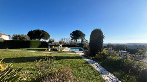 un jardin avec une piscine au loin dans l'établissement Nouveau Le Mas des Serens, à La Gaude