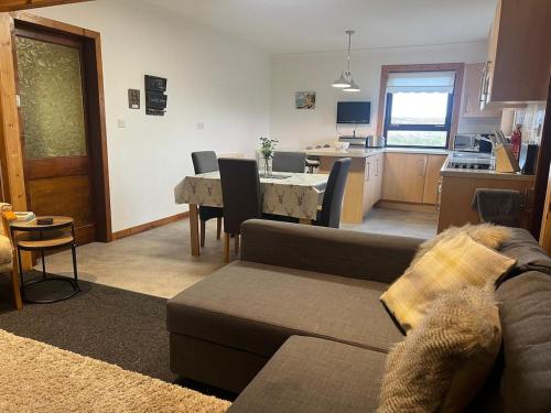 un soggiorno con un divano, un tavolo e una cucina di Isle-of-Lewis delightful cosy croft house retreat a Barvas