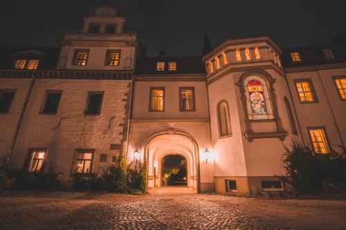 an entrance to a building with an archway at night at Hotel Schloss Schkopau in Schkopau