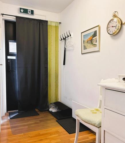 a room with a black shower curtain and a chair at En trappa upp in Malmö