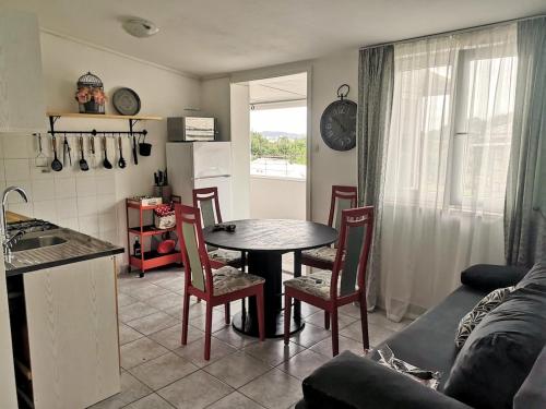 a kitchen and living room with a table and chairs at Apartman Luna Salona in Solin