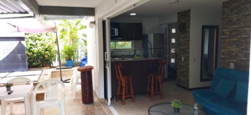 a kitchen and living room with a table and chairs at Hermoso Apartasol!! cerca a Plaza Principal, Aire Acondicionado, Vista a la Piscina in Santa Fe de Antioquia