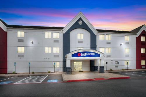 a large white building with a sign on it at Candlewood Suites Harrisonburg by IHG in Harrisonburg