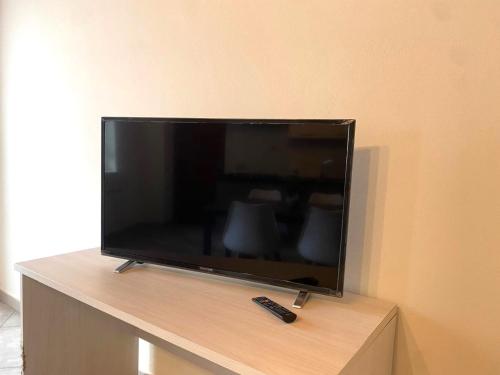 a flat screen tv sitting on a stand with a remote control at Appartamento Mi & Ti in CastellʼAlfero